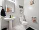 Powder room features a pedestal sink, neutral gray walls, and modern decor at 2322 Coach Way, Jonesboro, GA 30236