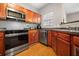 A functional kitchen with stainless steel appliances, wooden cabinets and wood-look flooring at 2322 Coach Way, Jonesboro, GA 30236
