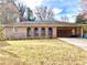 Charming brick home featuring a well-manicured lawn, covered parking, and a welcoming facade at 3081 Oak Dr, Lawrenceville, GA 30044