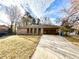 Well-maintained front yard showcasing the home's brick facade, arched entryway, and a convenient carport at 3081 Oak Dr, Lawrenceville, GA 30044