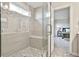A luxurious glass-enclosed shower with a built-in bench and stylish mosaic tile accents at 135 Eastmark Way, Fayetteville, GA 30214