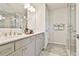 A modern bathroom with double vanity, tile flooring, and glass-enclosed shower at 135 Eastmark Way, Fayetteville, GA 30214