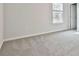 This bedroom has neutral walls with a window and a door at 135 Eastmark Way, Fayetteville, GA 30214