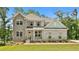 Charming two-story home featuring a mix of brick and stone facade, complemented by a well-manicured lawn at 135 Eastmark Way, Fayetteville, GA 30214