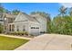 Side view of a two-story home featuring a two-car garage and a well-maintained lawn at 135 Eastmark Way, Fayetteville, GA 30214