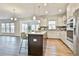 Bright, open kitchen showcasing an island with seating, stainless appliances, and abundant cabinet space at 135 Eastmark Way, Fayetteville, GA 30214