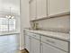 Bright kitchen adjacent to the living room with granite countertops, stainless appliances, and stylish cabinetry at 135 Eastmark Way, Fayetteville, GA 30214