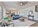 Open-concept living room flowing into the kitchen with a staircase and comfortable seating at 135 Eastmark Way, Fayetteville, GA 30214