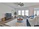 Inviting living room featuring a ceiling fan, large windows, and comfortable seating arrangements at 135 Eastmark Way, Fayetteville, GA 30214
