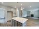 Kitchen island with gray cabinets and quartz countertop, flowing into a living area with a fireplace at 250 Arnewood Cir, Mcdonough, GA 30253
