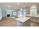 Kitchen island featuring quartz countertop, in an open floorplan to living area with fireplace and backyard access at 250 Arnewood Cir, Mcdonough, GA 30253