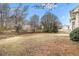 Expansive backyard featuring a large grassy area, mature trees, and a concrete patio space at 2549 Greenville Way, Decatur, GA 30034