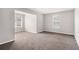 Open-concept living room with neutral walls, carpet, and natural light from two windows at 2549 Greenville Way, Decatur, GA 30034