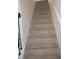 Carpeted staircase leading to the upper level, featuring neutral tones and a classic design at 2139 Theberton Trl, Locust Grove, GA 30248