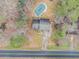 Aerial view of a cozy home with a covered pool, driveway, and surrounding trees at 620 Bell Se Rd, Conyers, GA 30094