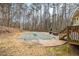 Backyard featuring a pool, a patio, a wooden deck, a grill, and surrounded by tall trees at 620 Bell Se Rd, Conyers, GA 30094