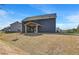 Exterior showcasing the backyard with a covered patio and lawn at 132 Felicity Pike, Locust Grove, GA 30248