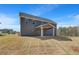 Exterior view of the home's backyard featuring covered patio and lawn at 132 Felicity Pike, Locust Grove, GA 30248