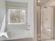 The bathroom features a soaking tub next to a window and a glass enclosed shower at 132 Felicity Pike, Locust Grove, GA 30248
