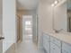 Bright bathroom features dual sinks with white cabinets, sleek fixtures, and a glass shower door at 132 Felicity Pike, Locust Grove, GA 30248