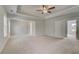 Large primary bedroom with carpet, tray ceilings, fan, and three large windows at 132 Felicity Pike, Locust Grove, GA 30248