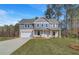 Charming two-story home with brick accents, a two-car garage and green lawn at 132 Felicity Pike, Locust Grove, GA 30248