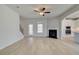 Open-concept living room with wood floors, fireplace, and a view into the kitchen at 132 Felicity Pike, Locust Grove, GA 30248