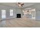 Bright open living room with fireplace that flows into a modern kitchen with white cabinets at 132 Felicity Pike, Locust Grove, GA 30248