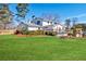 Expansive backyard featuring a lush lawn, wooden fence, and a charming white house with a wooden deck at 1771 Mount Vernon Rd, Atlanta, GA 30338