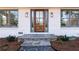 Inviting entryway with stone steps, a stylish wood door, and decorative outdoor lighting at 1771 Mount Vernon Rd, Atlanta, GA 30338