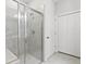 Modern bathroom with glass enclosed shower featuring gray tile and white hexagon tile floor at 3903 Shelleydale Dr, Powder Springs, GA 30127