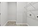 White laundry room with tile flooring, shelving and washer dryer hookups at 3903 Shelleydale Dr, Powder Springs, GA 30127