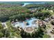 Expansive community pool featuring slides and lounge areas, set amidst verdant trees, lake, and parking at 918 Bridge Mill Ave, Canton, GA 30114