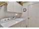 Bright laundry room features white washer and dryer with white cabinets and storage shelves at 918 Bridge Mill Ave, Canton, GA 30114