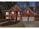 Charming brick home at twilight with a manicured lawn and attached two-car garage at 4275 Chastain Pointe Nw, Kennesaw, GA 30144