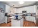 Well-lit kitchen featuring white cabinets, stainless steel appliances, and a center island at 4275 Chastain Pointe Nw, Kennesaw, GA 30144