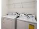 Functional laundry room with white washer and dryer and storage shelves at 4593 Parkway Cir, Atlanta, GA 30349