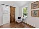 Bedroom sitting area with hardwood floors, chair, side table, and view of ensuite bathroom at 2133 Trailwood Rd, Decatur, GA 30032