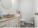 Small bathroom with vanity, toilet, and a round mirror at 2984 Superior Dr, Dacula, GA 30019