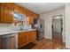 A kitchen with natural wood cabinets, stainless steel refrigerator, and hardwood floors at 2984 Superior Dr, Dacula, GA 30019