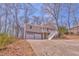 View of the house from the driveway, including a two-car garage, a porch, and natural surroundings at 322 Corley Cir, Hiram, GA 30141