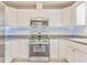 Close-up shot of the kitchen featuring white cabinets, stainless steel appliances, and stylish backsplash at 322 Corley Cir, Hiram, GA 30141