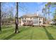 Spacious backyard featuring a well-maintained lawn, mature trees, and two-story home with a deck at 2162 Pine Mountain Nw Rd, Kennesaw, GA 30152