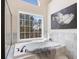 Luxurious bathroom featuring a soaking tub, a large window, and a separate glass shower at 2162 Pine Mountain Nw Rd, Kennesaw, GA 30152