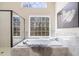 Luxurious bathroom featuring a soaking tub, a large window, and a separate glass shower at 2162 Pine Mountain Nw Rd, Kennesaw, GA 30152