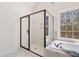 Bathroom featuring a frameless glass shower and separate tub with marble surround at 2162 Pine Mountain Nw Rd, Kennesaw, GA 30152