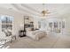 Spacious primary bedroom with tray ceilings, a ceiling fan, large windows, and a sitting area for relaxing at 2162 Pine Mountain Nw Rd, Kennesaw, GA 30152