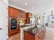 Bright kitchen features tile floors, stainless steel appliances, wooden cabinetry, and black countertops at 2162 Pine Mountain Nw Rd, Kennesaw, GA 30152