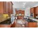 Bright kitchen features tile floors, stainless steel appliances, wooden cabinetry, and black countertops at 2162 Pine Mountain Nw Rd, Kennesaw, GA 30152