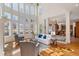 Spacious living room with a fireplace, hardwood floors, tall windows, and an open layout to the kitchen at 2162 Pine Mountain Nw Rd, Kennesaw, GA 30152
